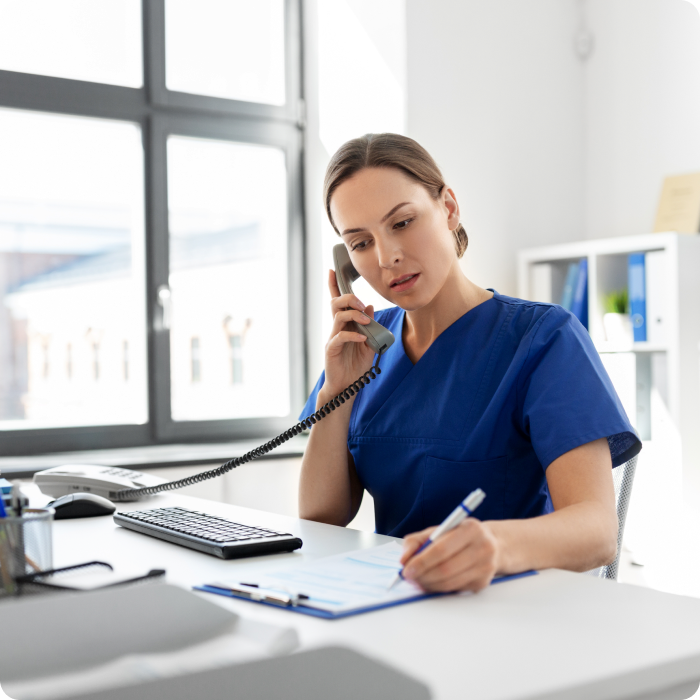 Assistante médicale au téléphone devant un ordinateur